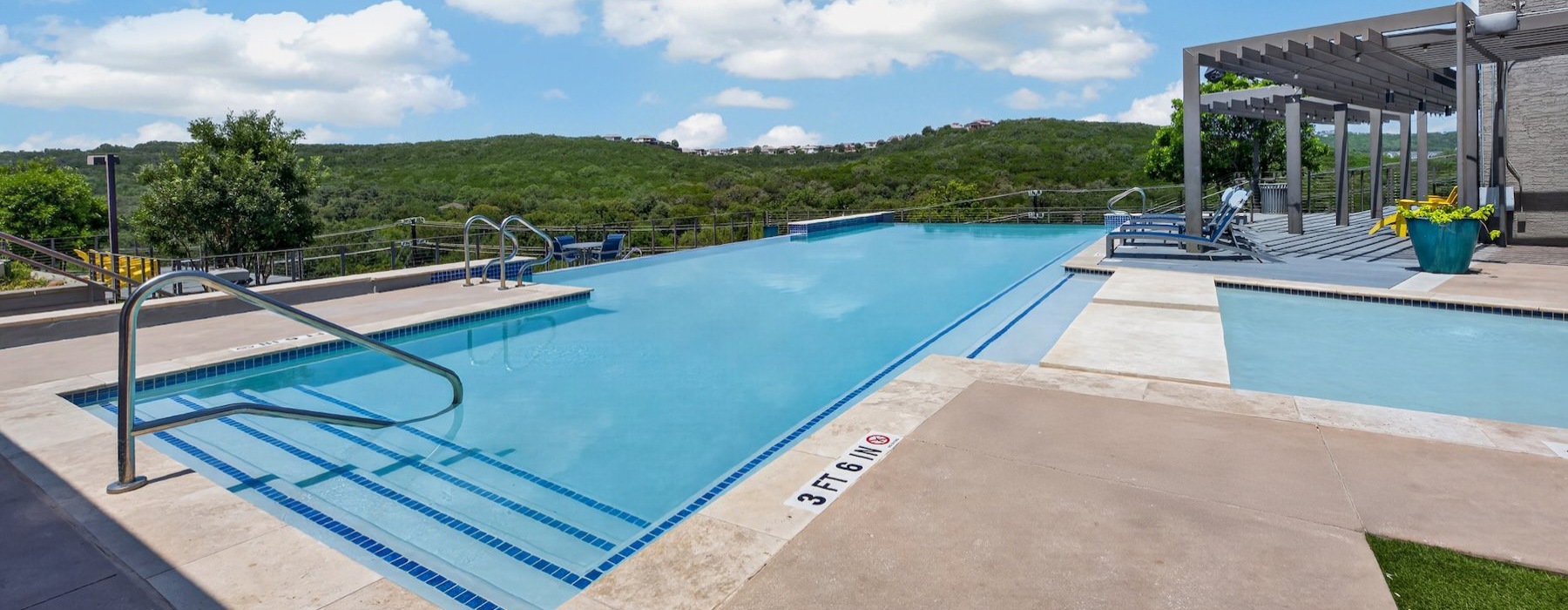 a swimming pool with a deck and trees in the background