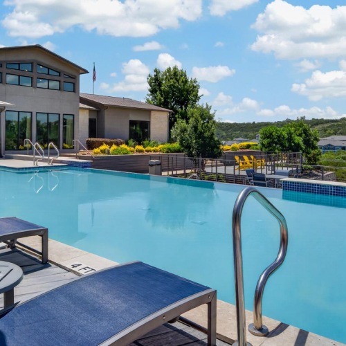 a pool with chairs and tables by it